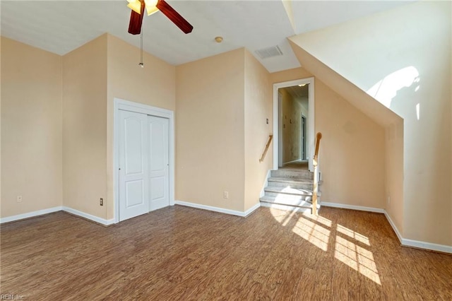 interior space with a ceiling fan, visible vents, baseboards, and wood finished floors