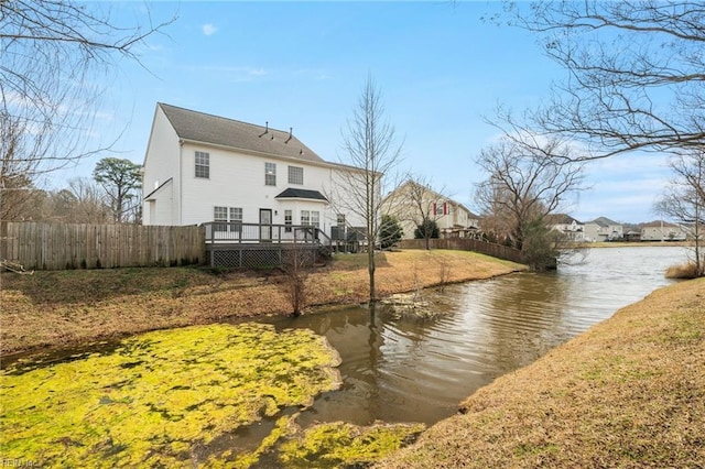 back of property featuring a deck with water view and fence