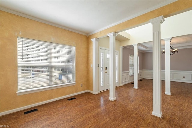 interior space featuring visible vents, ornamental molding, wood finished floors, and decorative columns