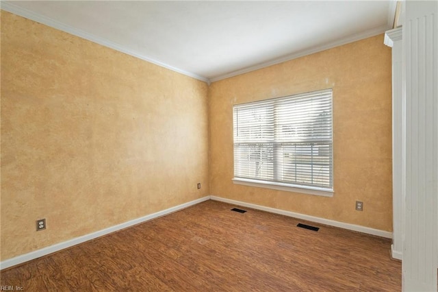 unfurnished room with baseboards, crown molding, visible vents, and wood finished floors