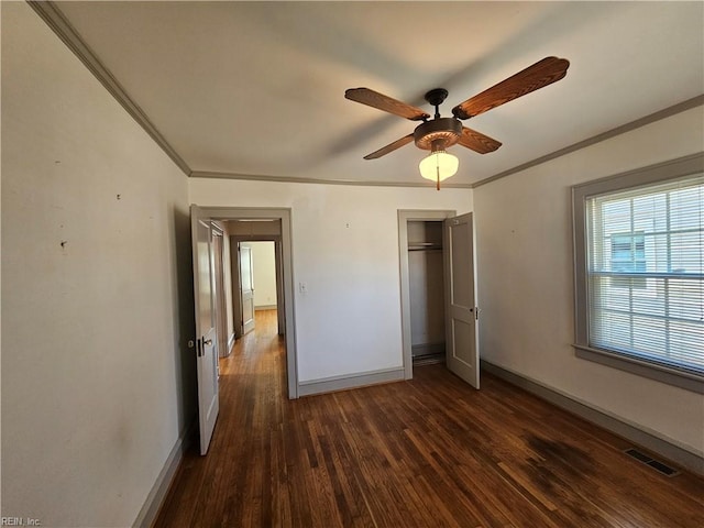 unfurnished bedroom featuring dark wood finished floors, visible vents, crown molding, and baseboards