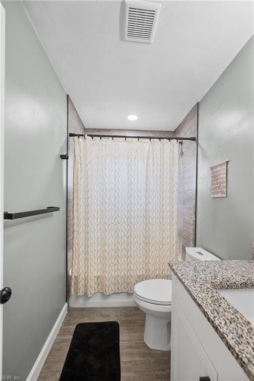 full bathroom with toilet, visible vents, wood finished floors, and vanity