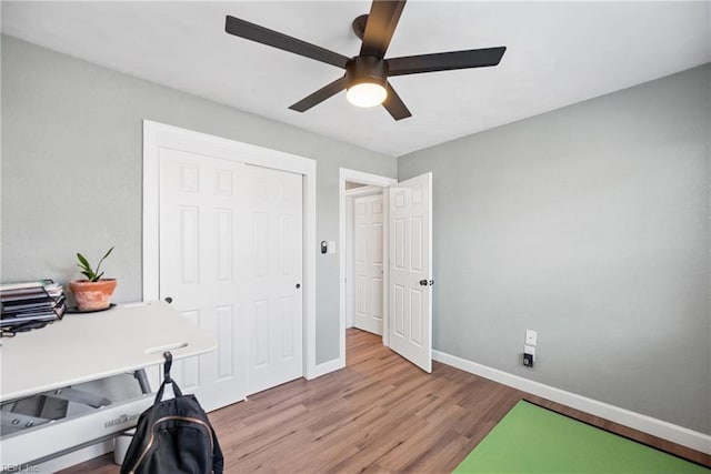 office featuring a ceiling fan, baseboards, and wood finished floors