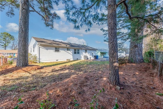 rear view of house with crawl space and fence