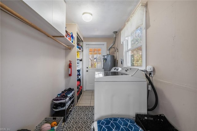 laundry area featuring light tile patterned floors, water heater, laundry area, and washing machine and clothes dryer