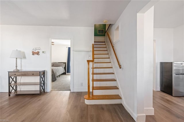 stairs with visible vents, baseboards, and wood finished floors