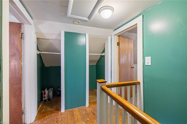 hallway featuring an upstairs landing and wood finished floors