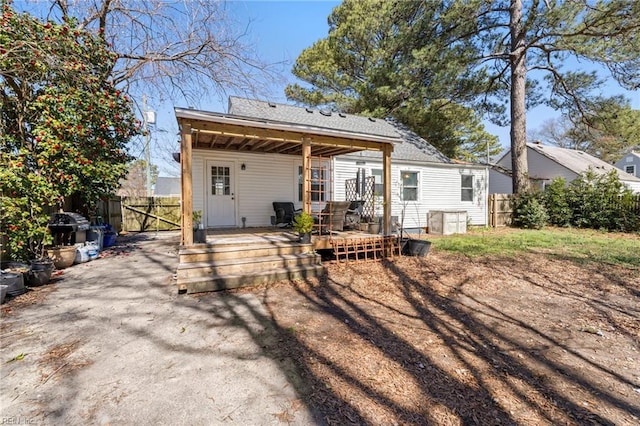 rear view of property featuring fence