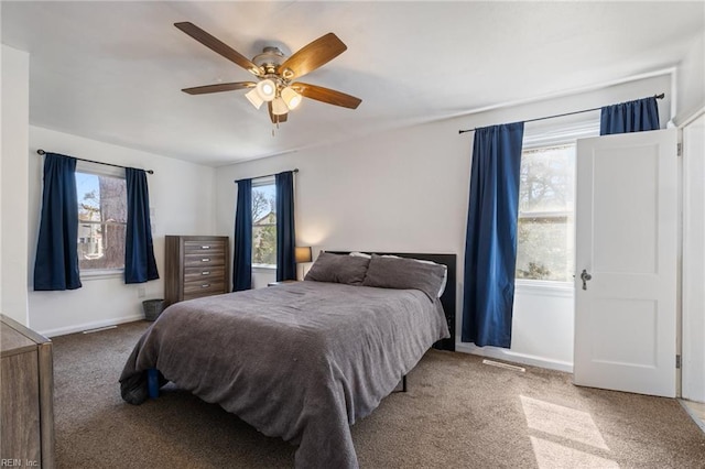 bedroom featuring multiple windows, carpet floors, baseboards, and ceiling fan