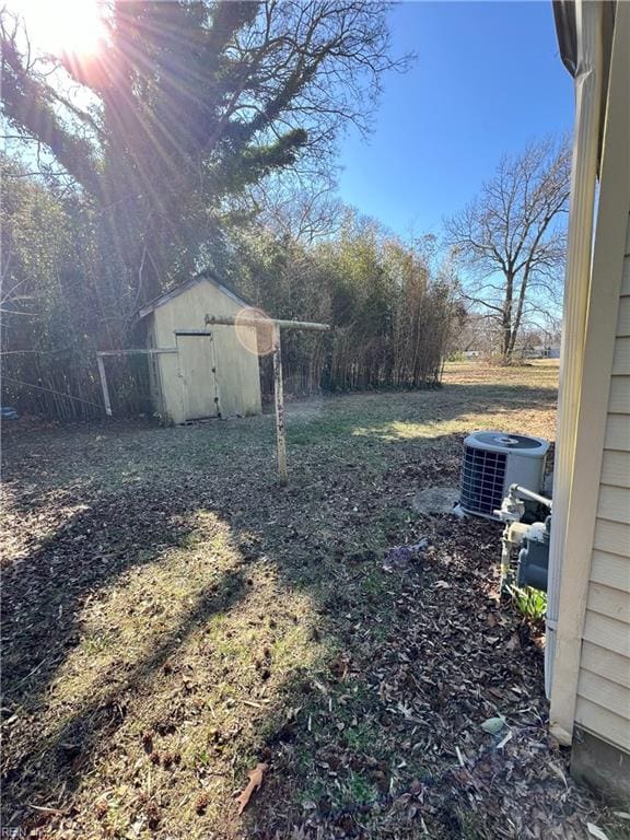 view of yard with a storage unit, central AC, and an outdoor structure