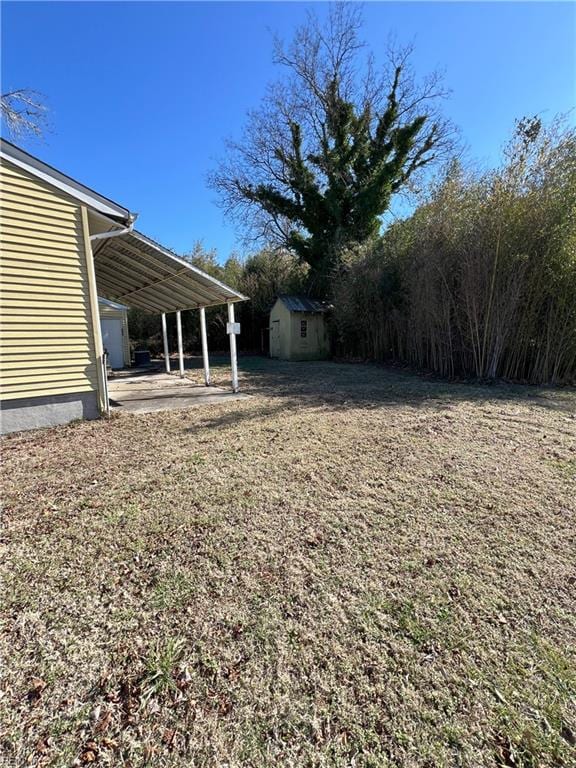 view of yard featuring an outbuilding, a carport, and a storage unit