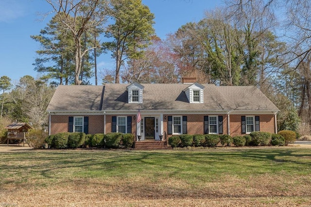 cape cod house with brick siding and a front lawn