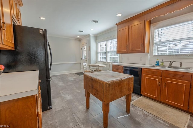 kitchen with black appliances, a sink, visible vents, and brown cabinets