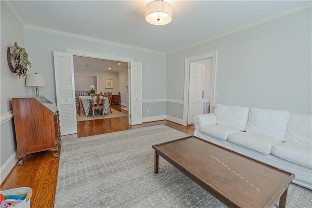 living room featuring ornamental molding, wood finished floors, and baseboards