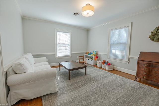 interior space with visible vents, crown molding, baseboards, and wood finished floors