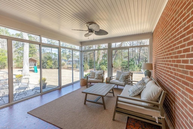 sunroom featuring a ceiling fan and wooden ceiling