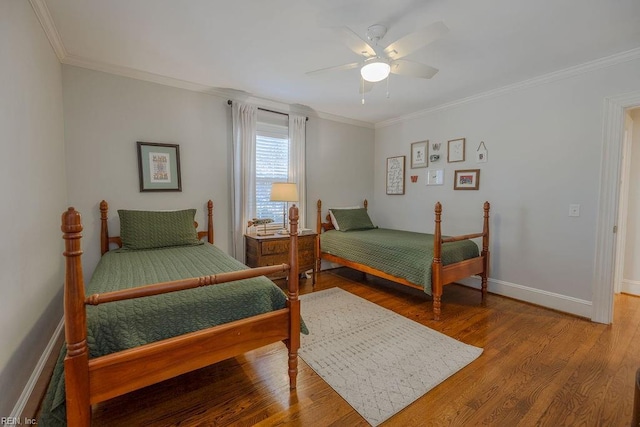 bedroom with ornamental molding, wood finished floors, a ceiling fan, and baseboards