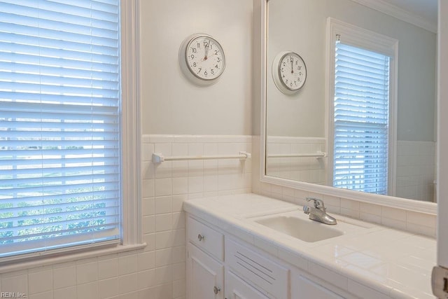 bathroom with ornamental molding, tile walls, wainscoting, and vanity