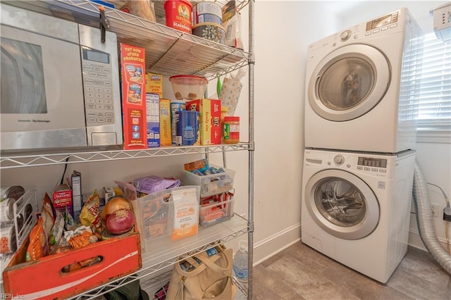 laundry area featuring stacked washer and dryer, laundry area, and baseboards