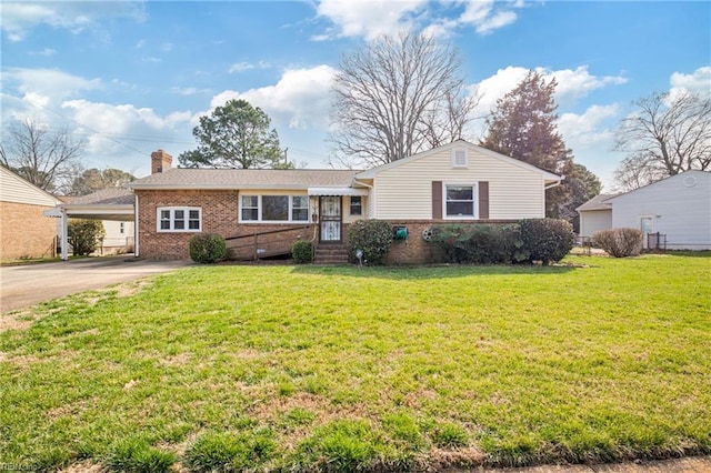 view of front of home featuring brick siding, a front lawn, concrete driveway, a chimney, and a carport