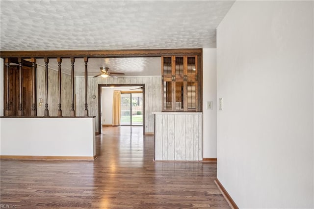 unfurnished room featuring ceiling fan, a textured ceiling, baseboards, and wood finished floors