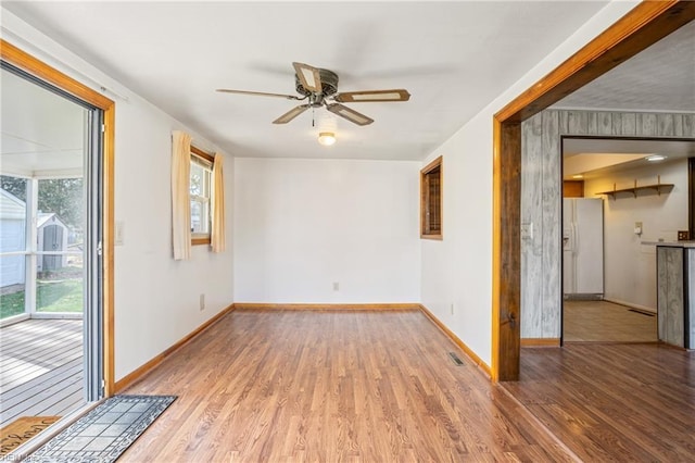 empty room with ceiling fan, baseboards, and wood finished floors