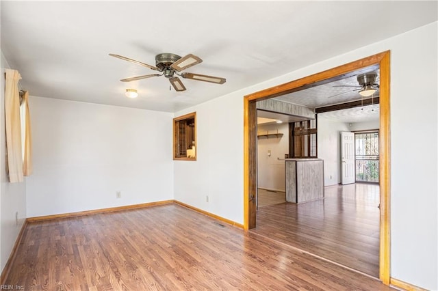 spare room featuring baseboards, ceiling fan, and wood finished floors