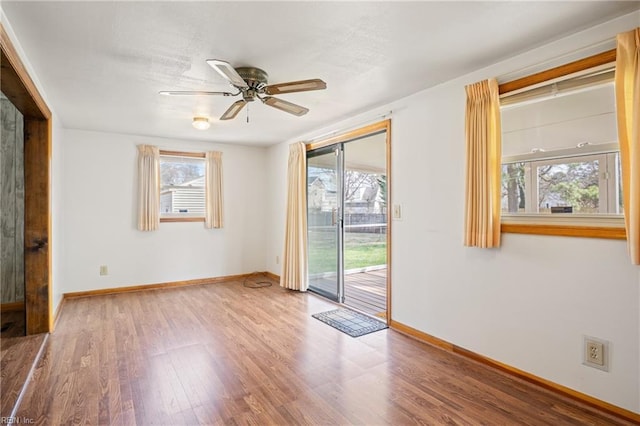 spare room featuring wood finished floors, baseboards, and a wealth of natural light