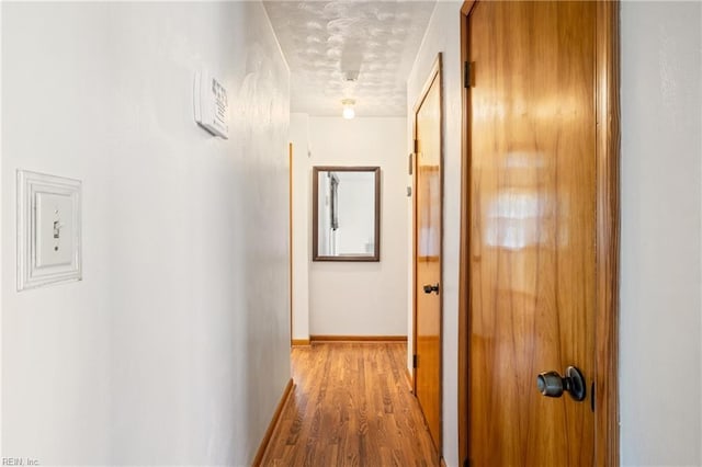 hallway with baseboards and wood finished floors