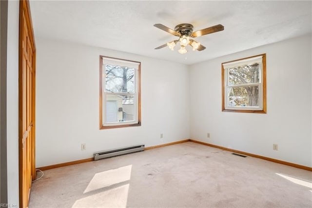 unfurnished room with a wealth of natural light, a baseboard radiator, baseboards, and carpet