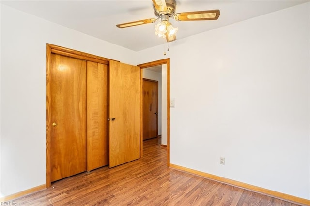 unfurnished bedroom with a closet, light wood-style flooring, baseboards, and ceiling fan