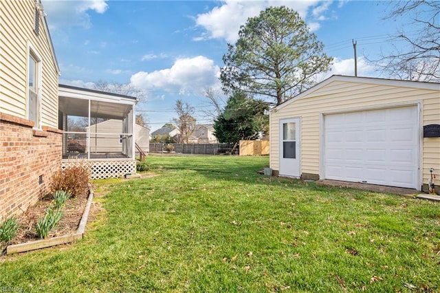 view of yard with a sunroom, an outdoor structure, and fence