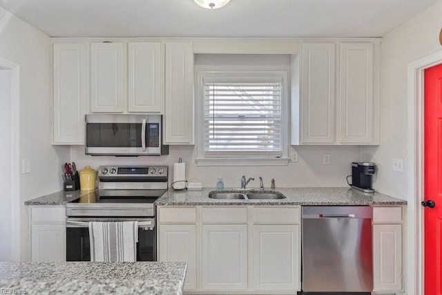 kitchen featuring appliances with stainless steel finishes, a sink, and white cabinets