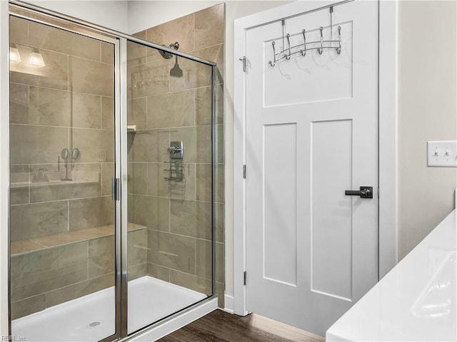 full bathroom featuring a shower stall and wood finished floors