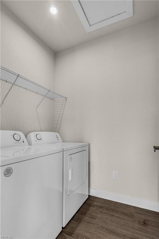 washroom with laundry area, washing machine and clothes dryer, dark wood finished floors, and baseboards