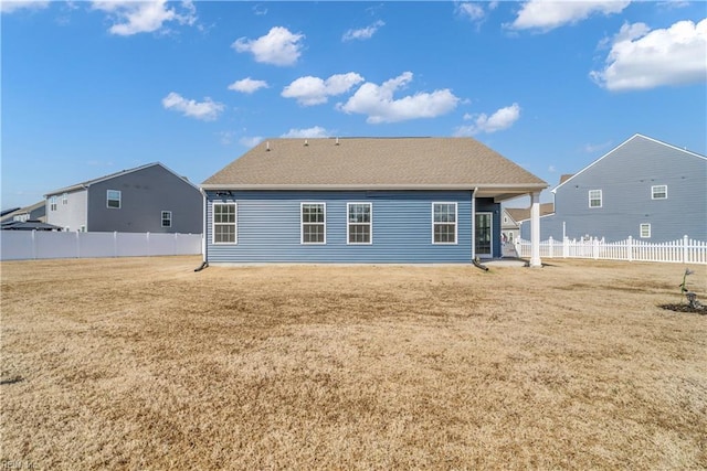 back of property featuring a yard and fence