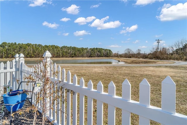 view of yard with a water view and fence