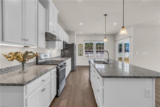 kitchen with a center island with sink, stainless steel appliances, white cabinets, a sink, and under cabinet range hood