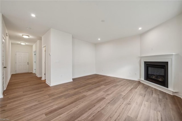 unfurnished living room with baseboards, light wood-style flooring, and recessed lighting