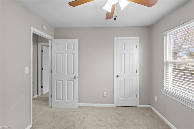 unfurnished bedroom featuring a ceiling fan, carpet, and baseboards