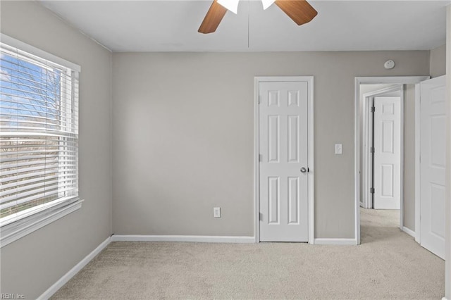 unfurnished bedroom featuring baseboards, multiple windows, and carpet