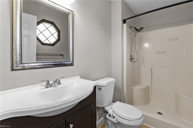 bathroom featuring a shower, toilet, and vanity