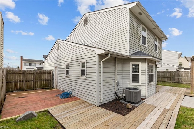 rear view of property featuring a fenced backyard, central AC, and a deck