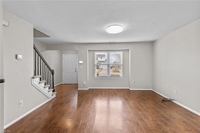 entryway with hardwood / wood-style floors, stairs, and baseboards