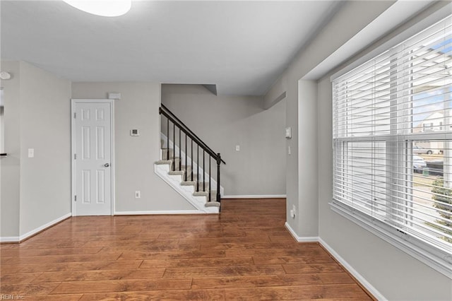 foyer featuring stairs, baseboards, and wood finished floors