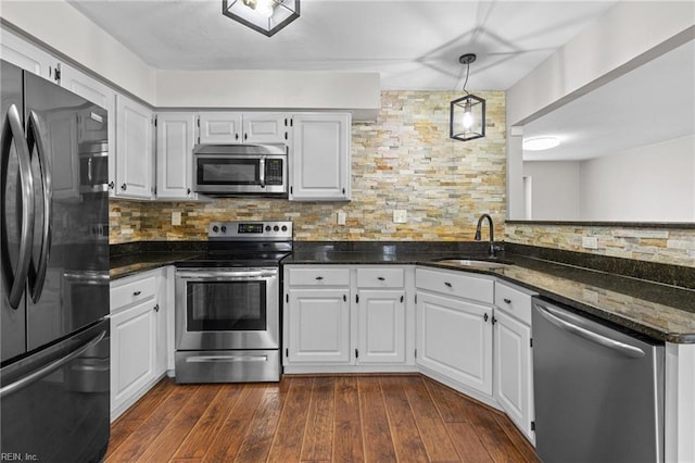 kitchen featuring a sink, stainless steel appliances, dark wood finished floors, and decorative backsplash