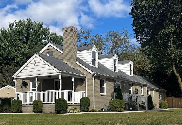 view of front of property featuring covered porch, brick siding, and a front yard