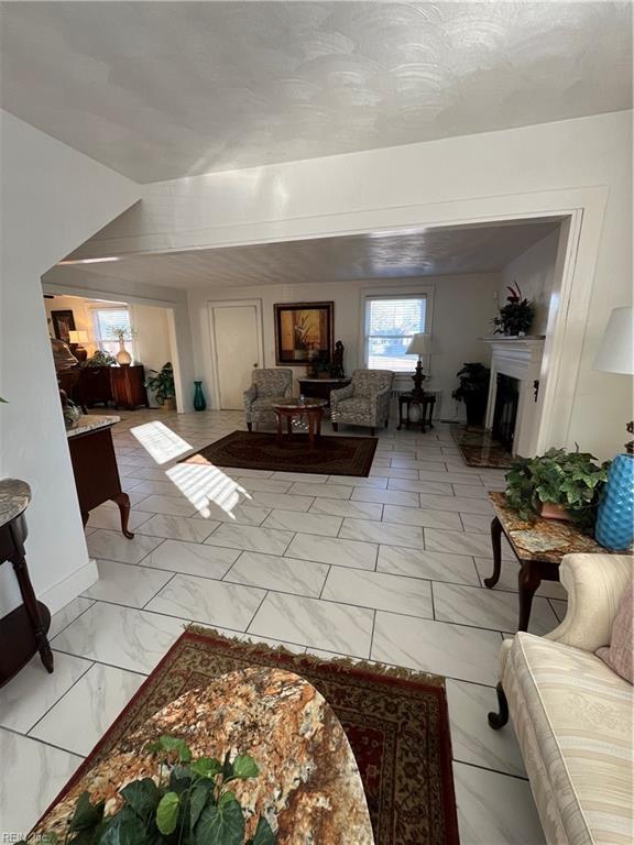 living area with marble finish floor and a fireplace with raised hearth