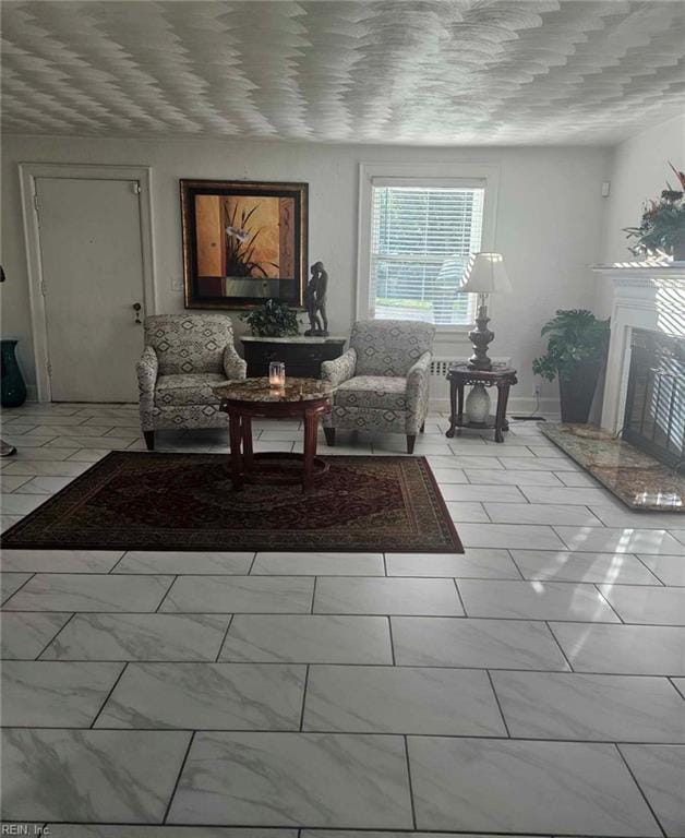 living area with marble finish floor and a high end fireplace