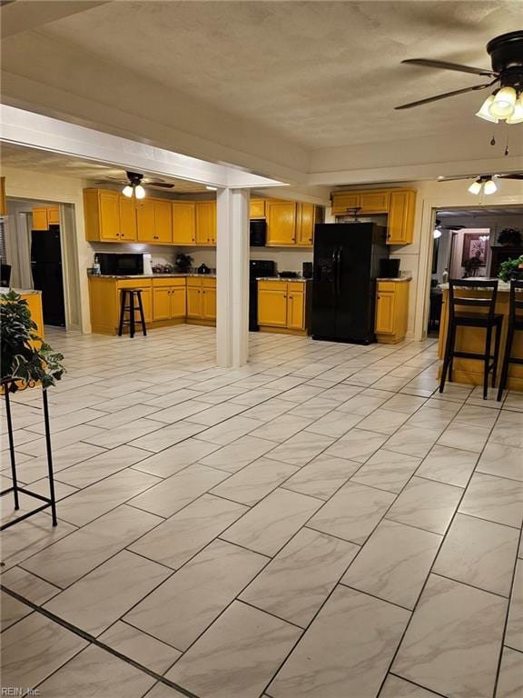 kitchen with ceiling fan, black appliances, and dark countertops